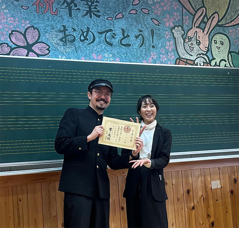Student and teacher holding a diploma